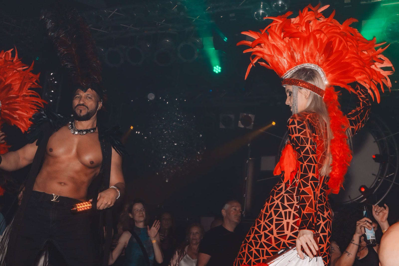 Performer mit rotem Federkopfschmuck im Club